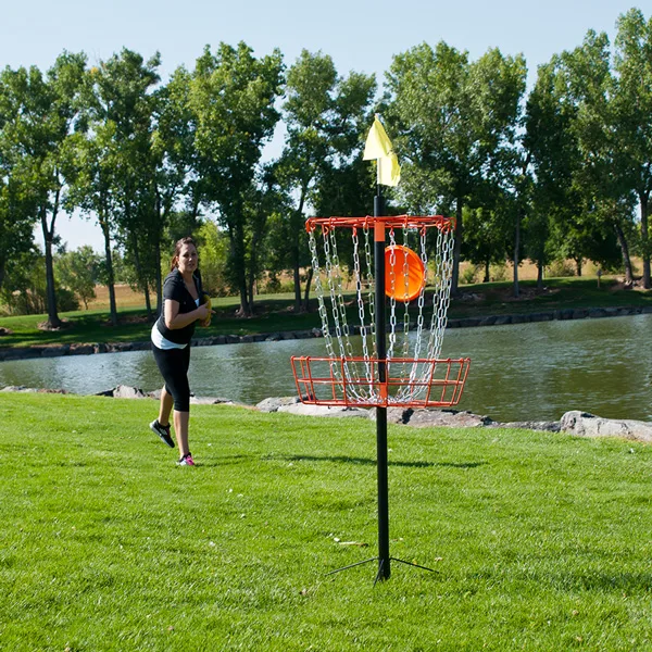 Discgolfspelare kastar mot korg på discgolfbana