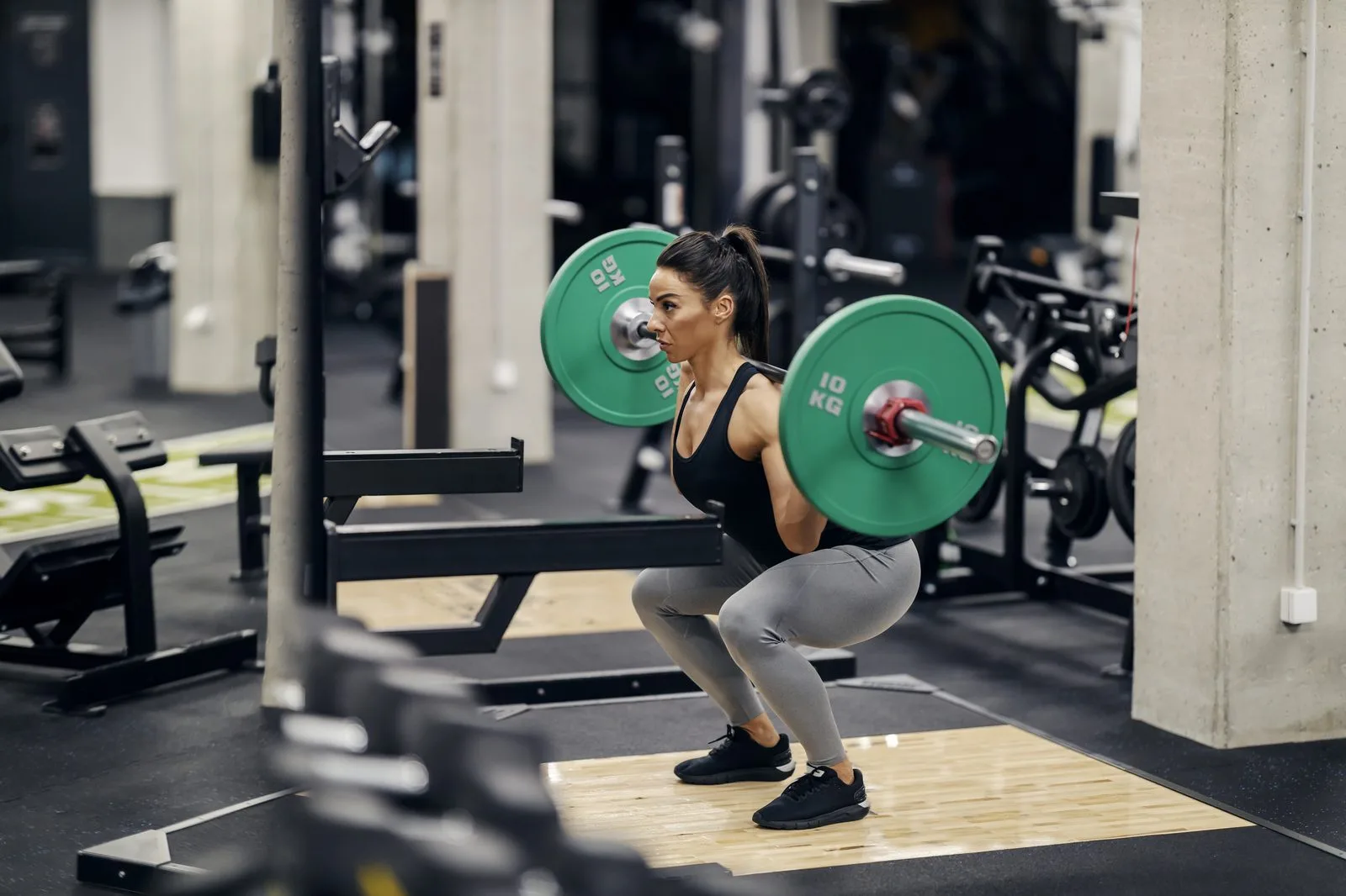 Nybörjare tränar knäböj med god teknik på gym